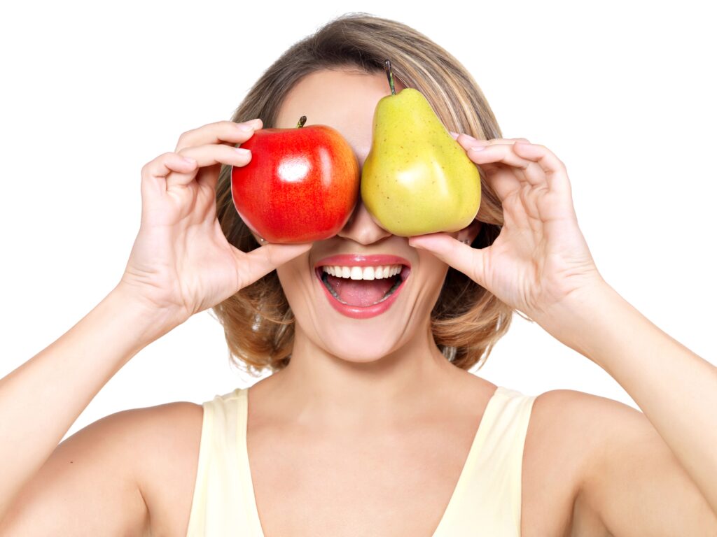 Mujer sonriendo con frutas en las manos